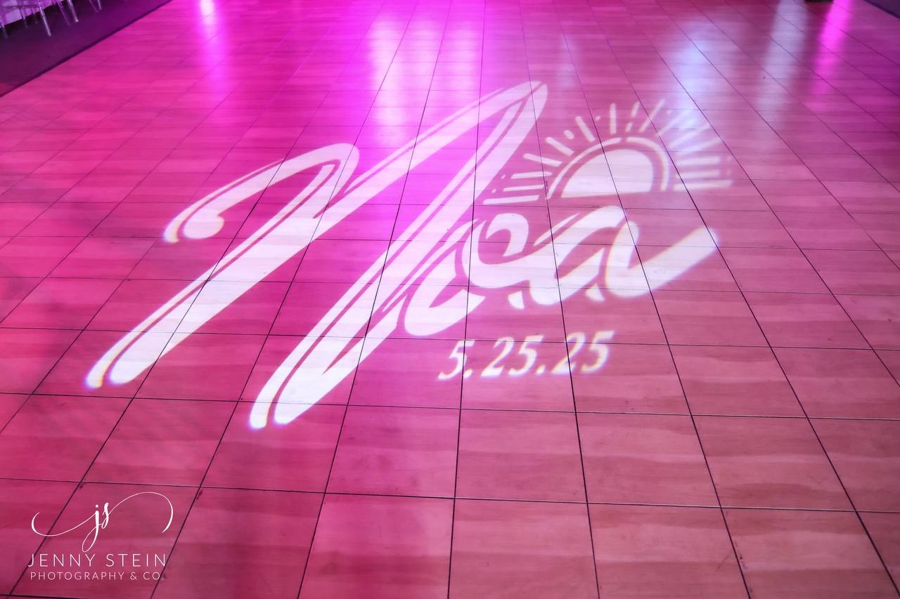Custom name and date projection on a pink-lit dance floor