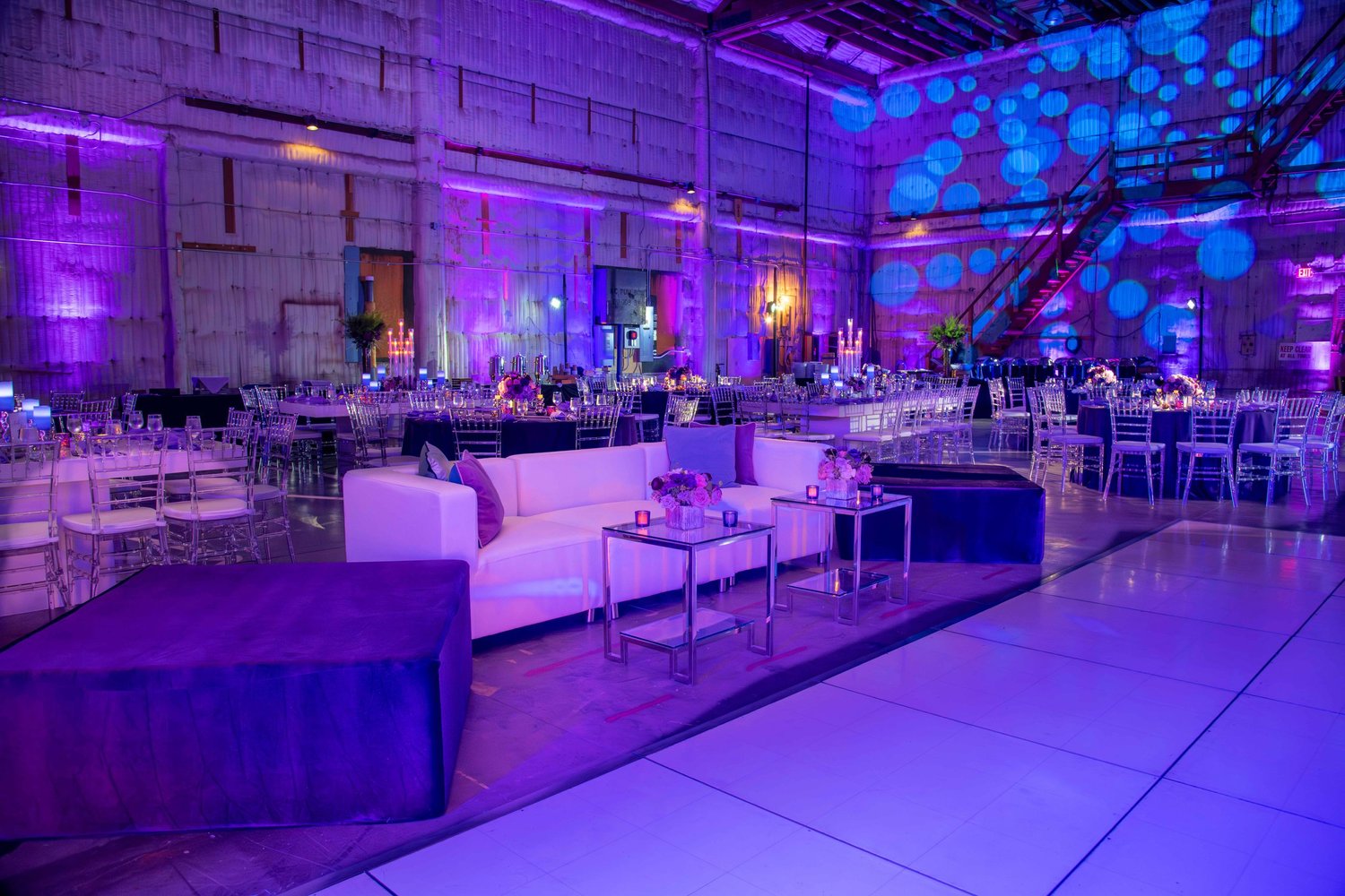 Bird DJs event space illuminated with purple lighting and a large LED backdrop
